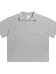 Boxy knit polo shirt in gray with a patch pocket and open collar.