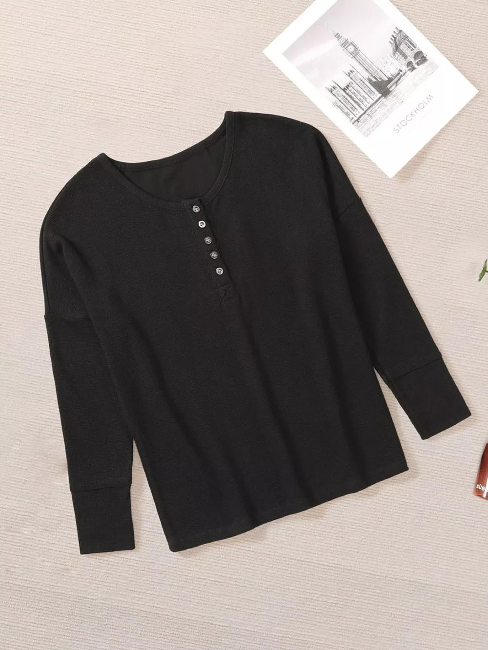 Black textured buttoned henley maternity shirt with long sleeves.