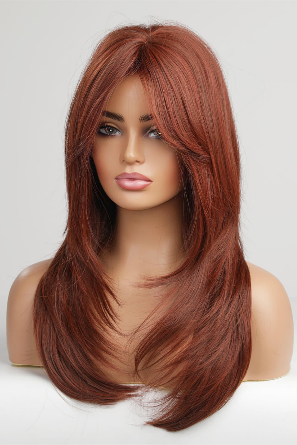 Layered copper red synthetic wig with chic bangs and face-framing layers.