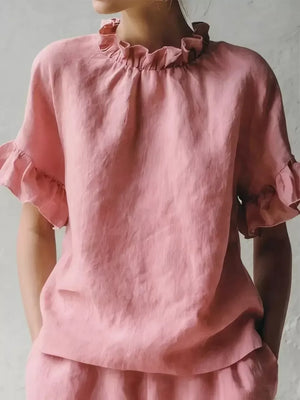 Pink ruffled neck half-sleeve shirt with ruffled cuffs.