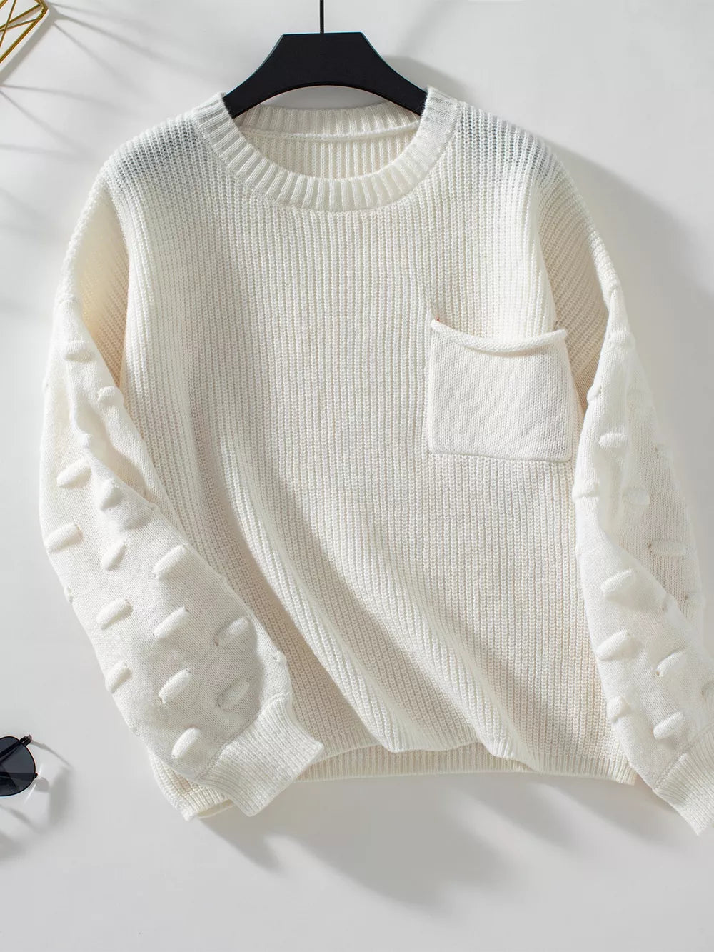 Ivory knit sweater with textured sleeves and chest pocket.