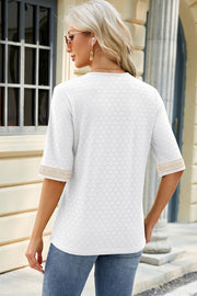 White textured V-neck blouse with lace trim on sleeves.