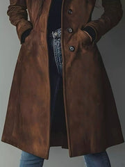 Brown long-sleeve trench coat with button closure and pockets, styled with jeans.