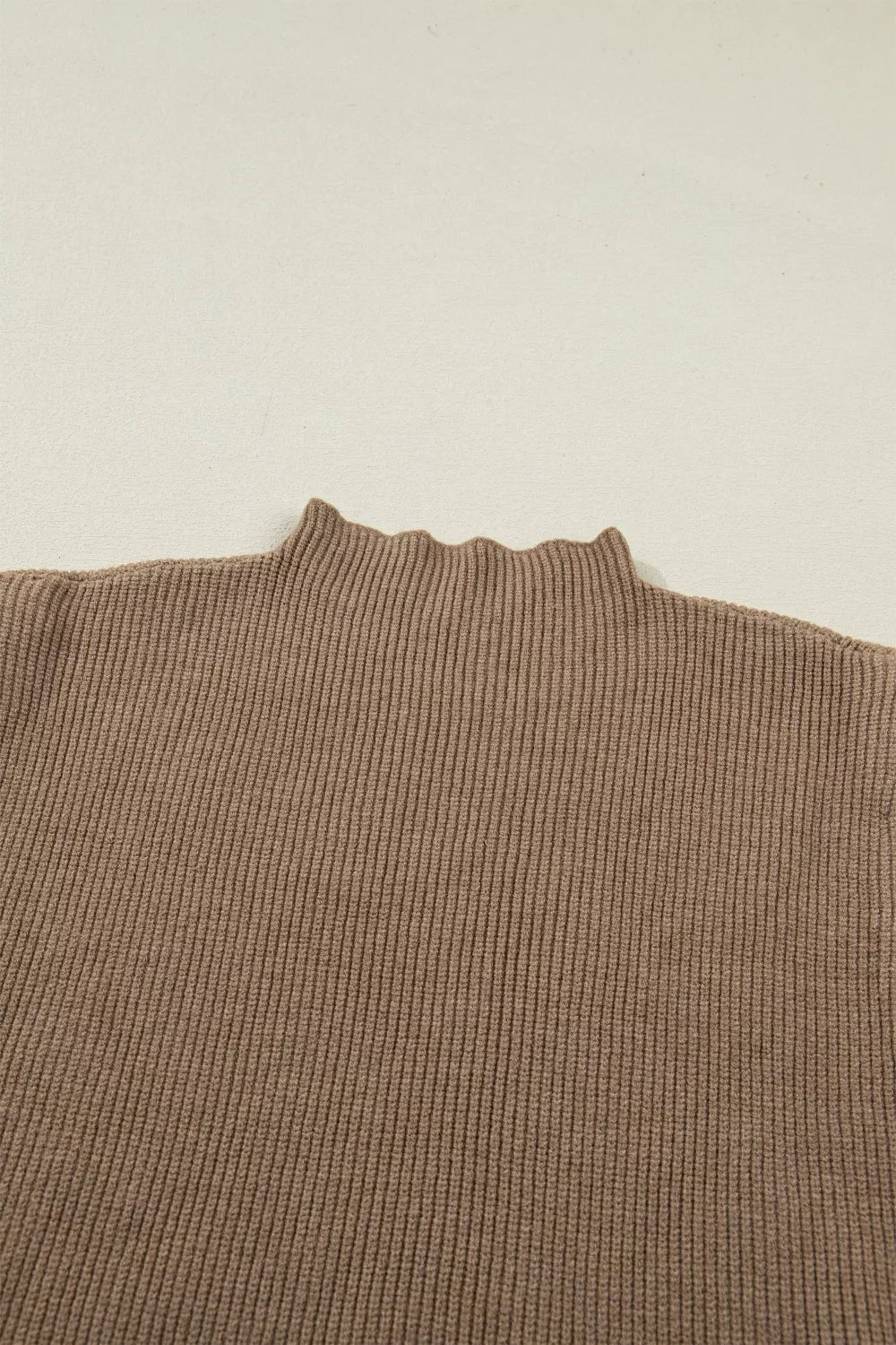 Brown ribbed knit mock neck sweater vest with lettuce edge detail.