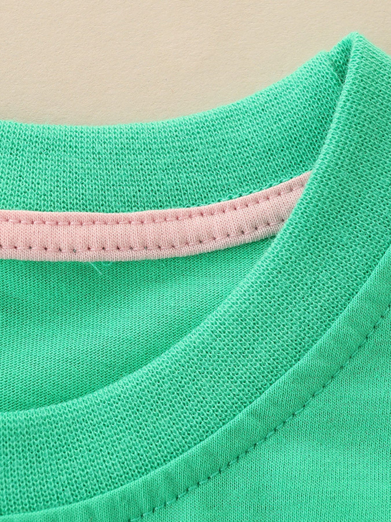 Green cotton toddler t-shirt with pink trim detail at neckline.