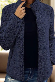Navy teddy fleece zip-up jacket with stand-up collar and full zip closure.