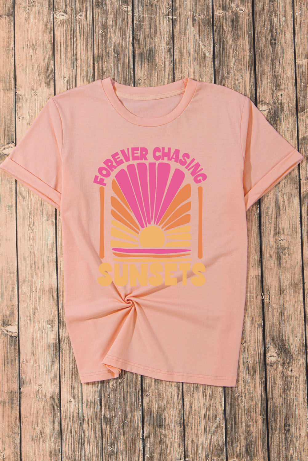Watermelon pink graphic tee with sunset design and text.
