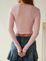 Dusty pink ribbed crop top with long sleeves and a scoop neck, worn with a denim skirt.