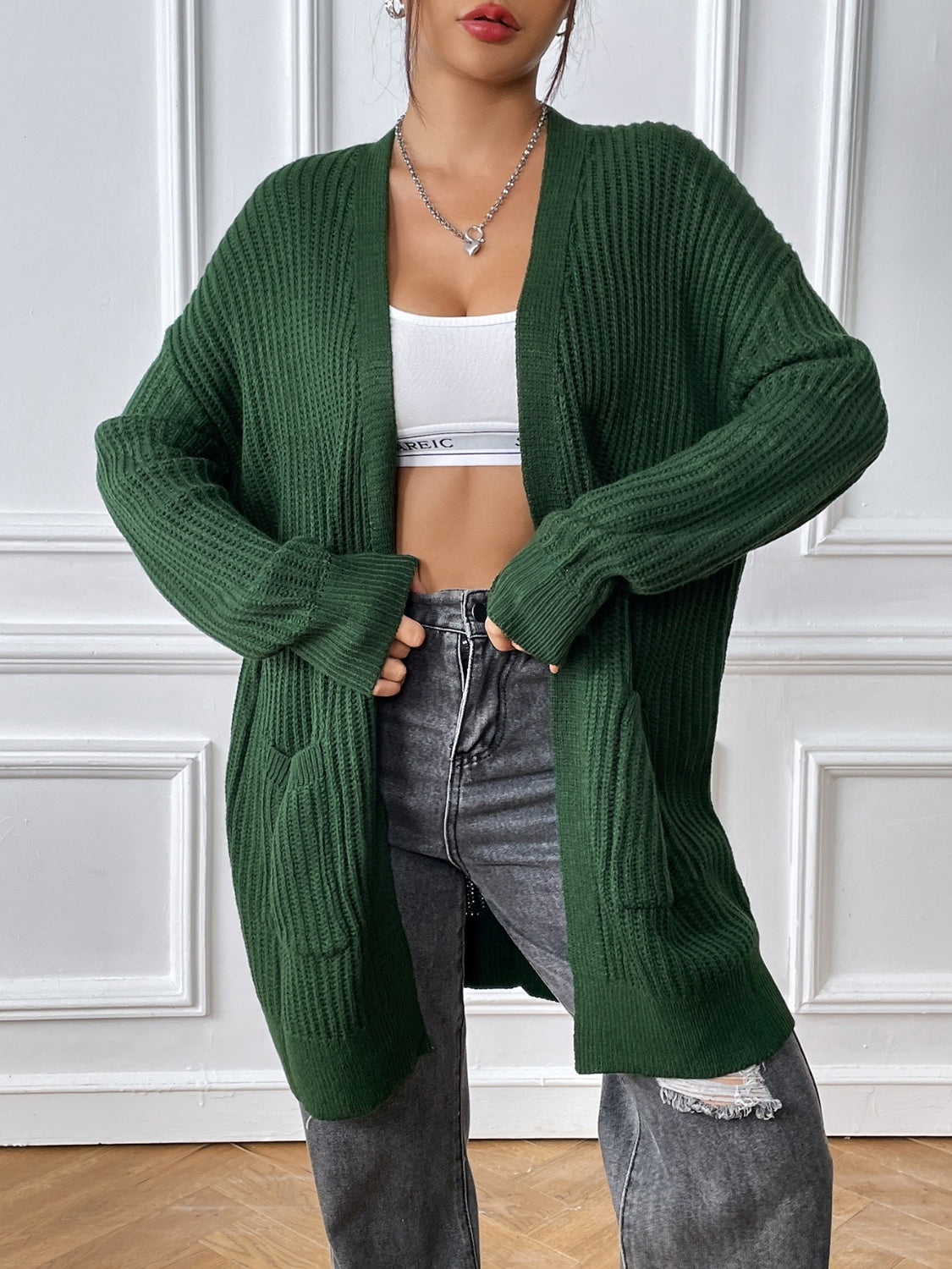 Green ribbed knit longline cardigan with pockets and open front.