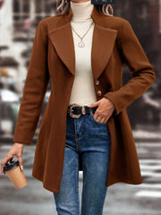 Caramel wool coat with flared hemline and button closure, styled with jeans.