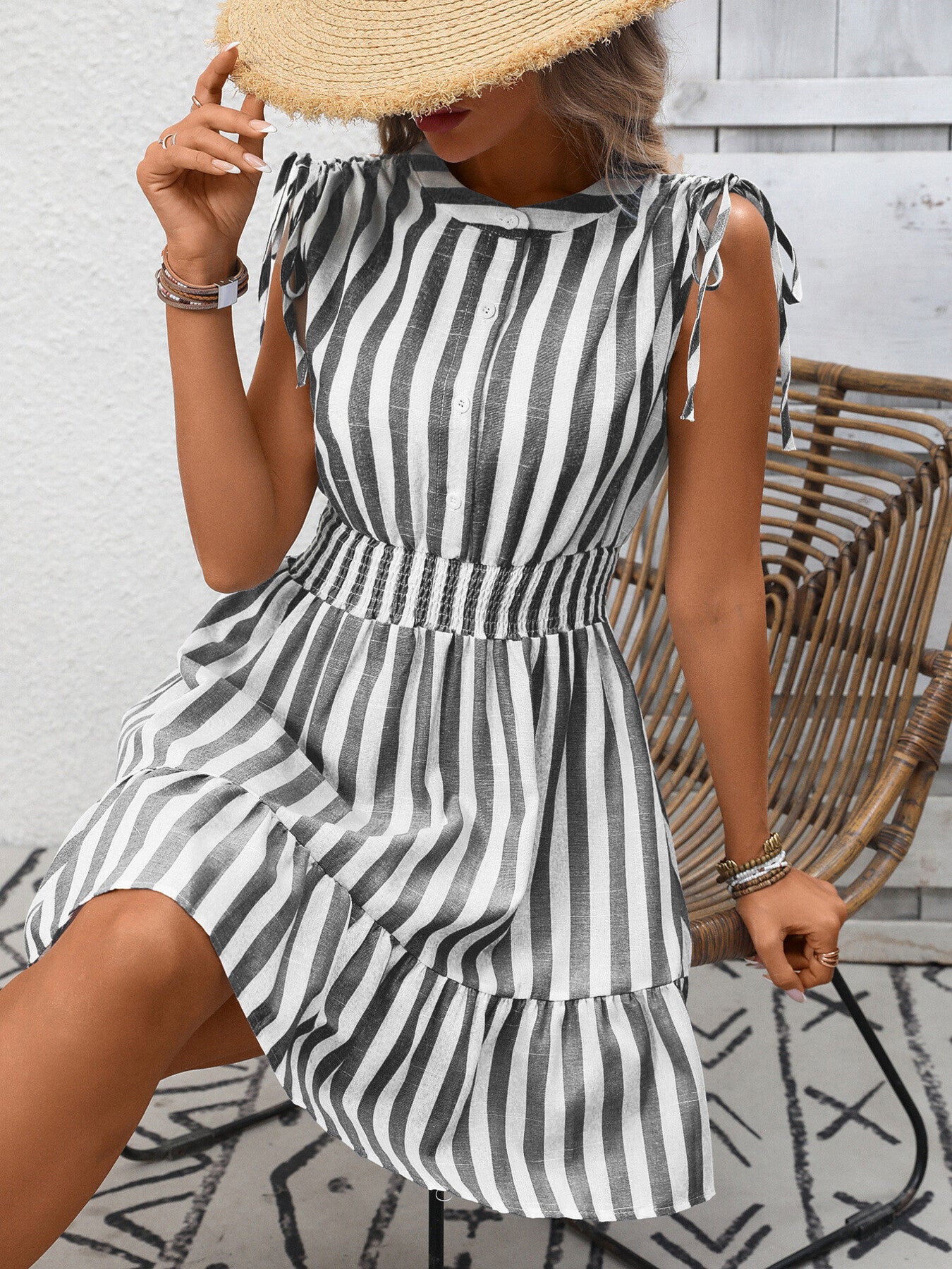 Striped summer dress with tied shoulders, button front, smocked waist, and ruffled hem.