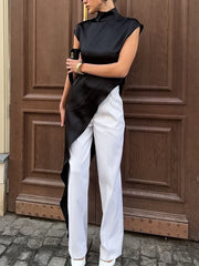 Black asymmetrical hem turtleneck blouse with cap sleeves and draped detail.
