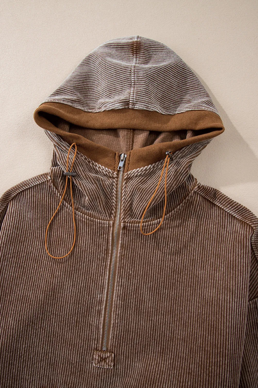 Brown corduroy pullover hoodie with quarter zip and adjustable drawstring hood.