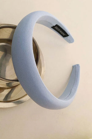 Light blue padded headband with textured fabric and a handmade tag