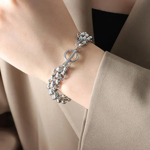 Silver triple-strand chain bracelet with toggle clasp and detailed clasp end.