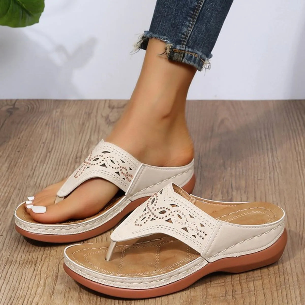 White laser-cut thong sandals with architectural detail and a cushioned sole.