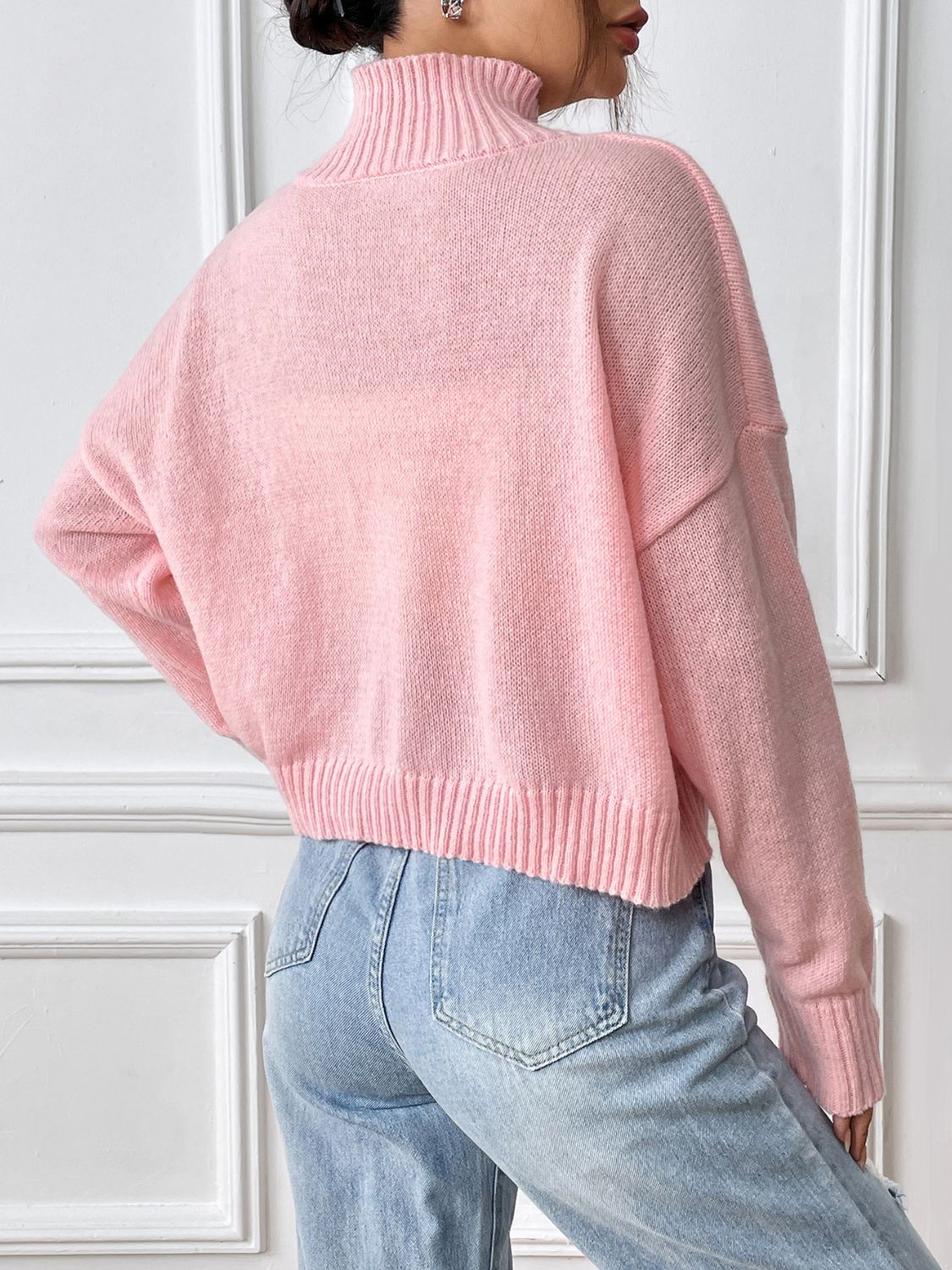 Blush pink knit turtleneck sweater with ribbed cuffs and hem.