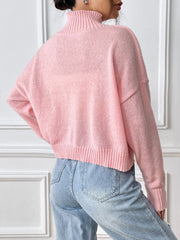Blush pink knit turtleneck sweater with ribbed cuffs and hem.