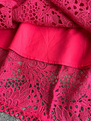 Fuchsia pink lace A-line dress with floral cutout detail and scalloped hem.