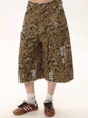 Men's distressed camo denim shorts with frayed hem and cargo pockets.