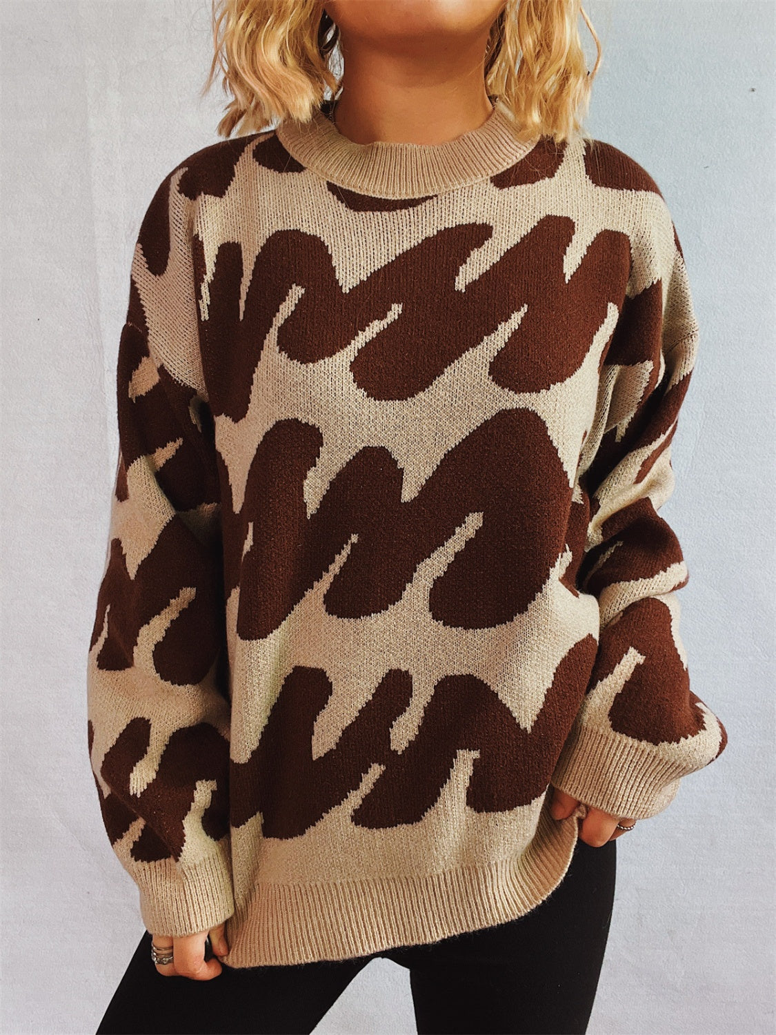 Graphic wave knit sweater in brown and camel with crew neck and long sleeves.