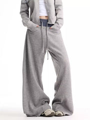 Grey wide-leg sweatpants with drawstring and pockets, styled with a cropped cardigan.