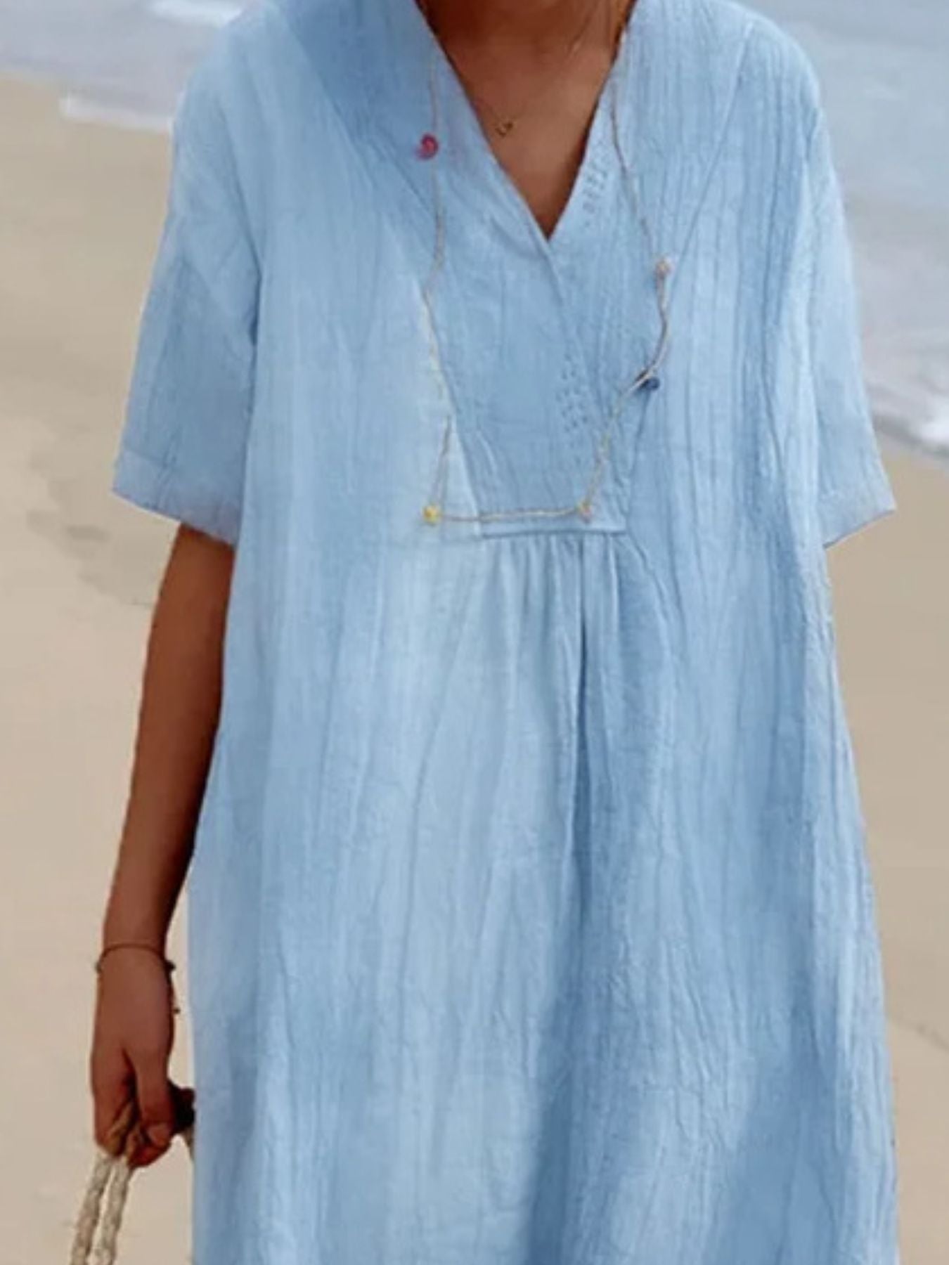 Blue V-neck casual midi dress with short sleeves and textured fabric.
