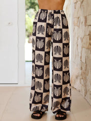 Black silk pajama pants with a checkerboard shell print and wide leg