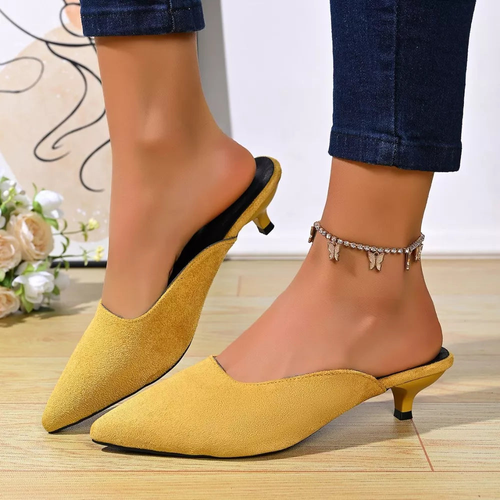 Yellow pointed-toe kitten heel mules with a suede finish.