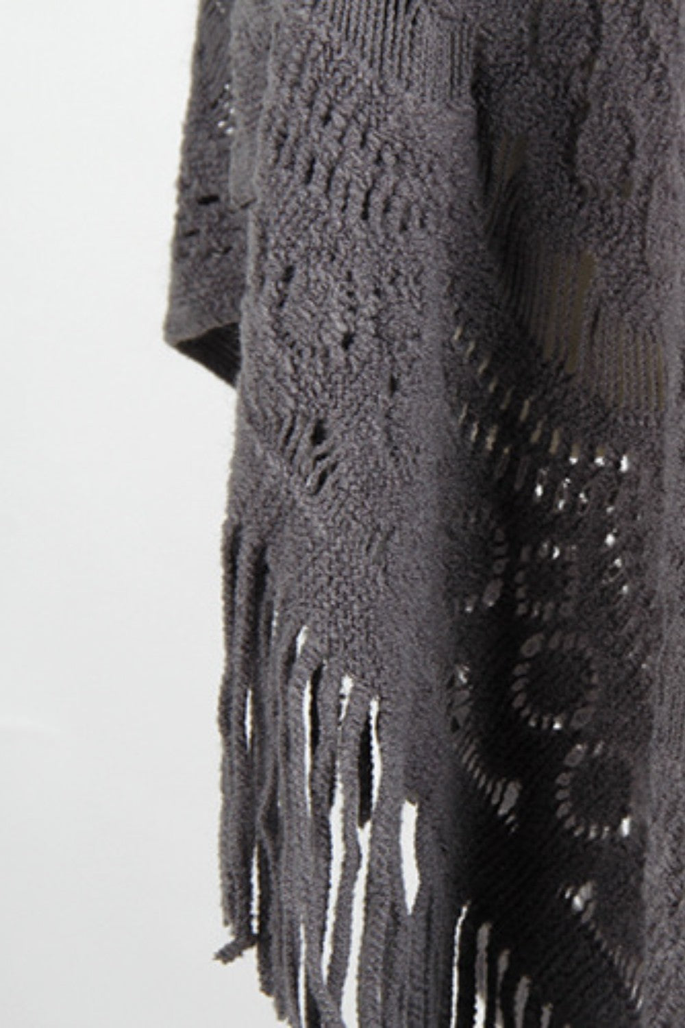Dark gray crochet poncho with openwork patterns and fringe detail.