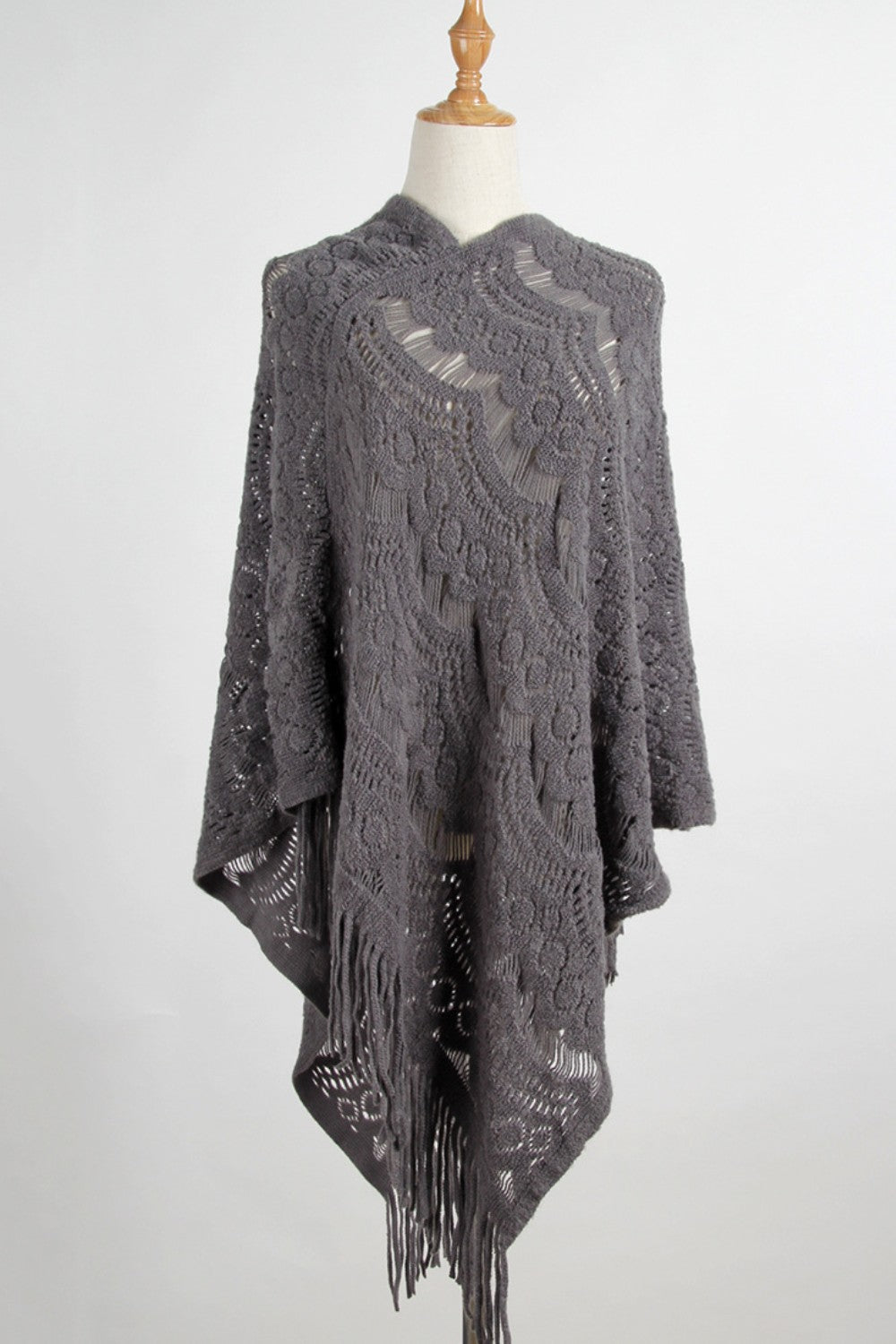 Dark gray textured crochet poncho with fringe and open knit pattern
