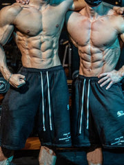 Black performance fleece jogger shorts with white drawstrings and subtle graphic details.
