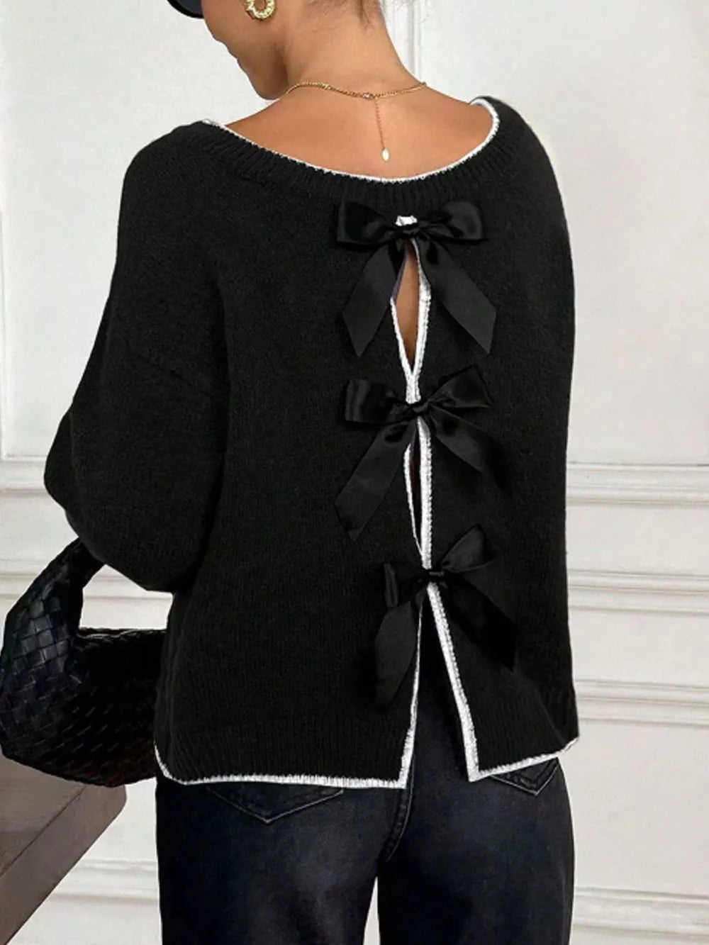 Black knit sweater with bowknot back detail and white trim