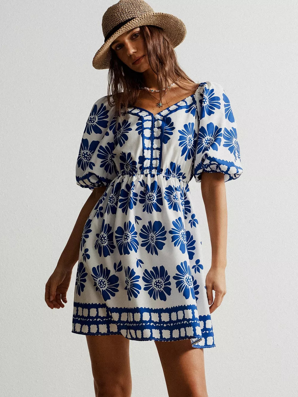 Charming floral puff sleeve mini dress with blue floral print and buttoned neckline.