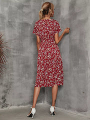 Wine red midi dress with a vibrant leaf pattern, V-neck, short sleeves, and an A-line cut.