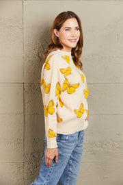 Apricot knit crewneck sweater with allover yellow butterfly motif and crew neckline.
