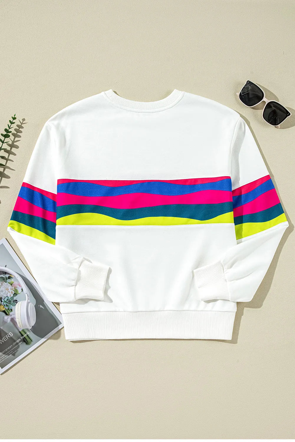 White crewneck sweatshirt with colorful horizontal stripes on chest and sleeves, ribbed cuffs and hem.