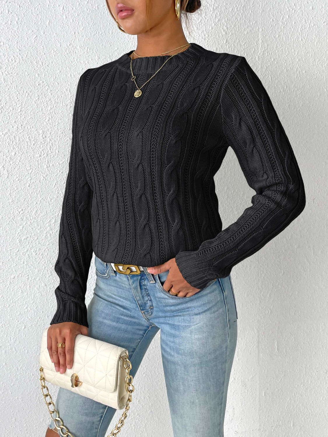 Black cable knit mock neck sweater with long sleeves.