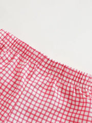 Baby shorts with pink and white gingham pattern and elastic waistband.