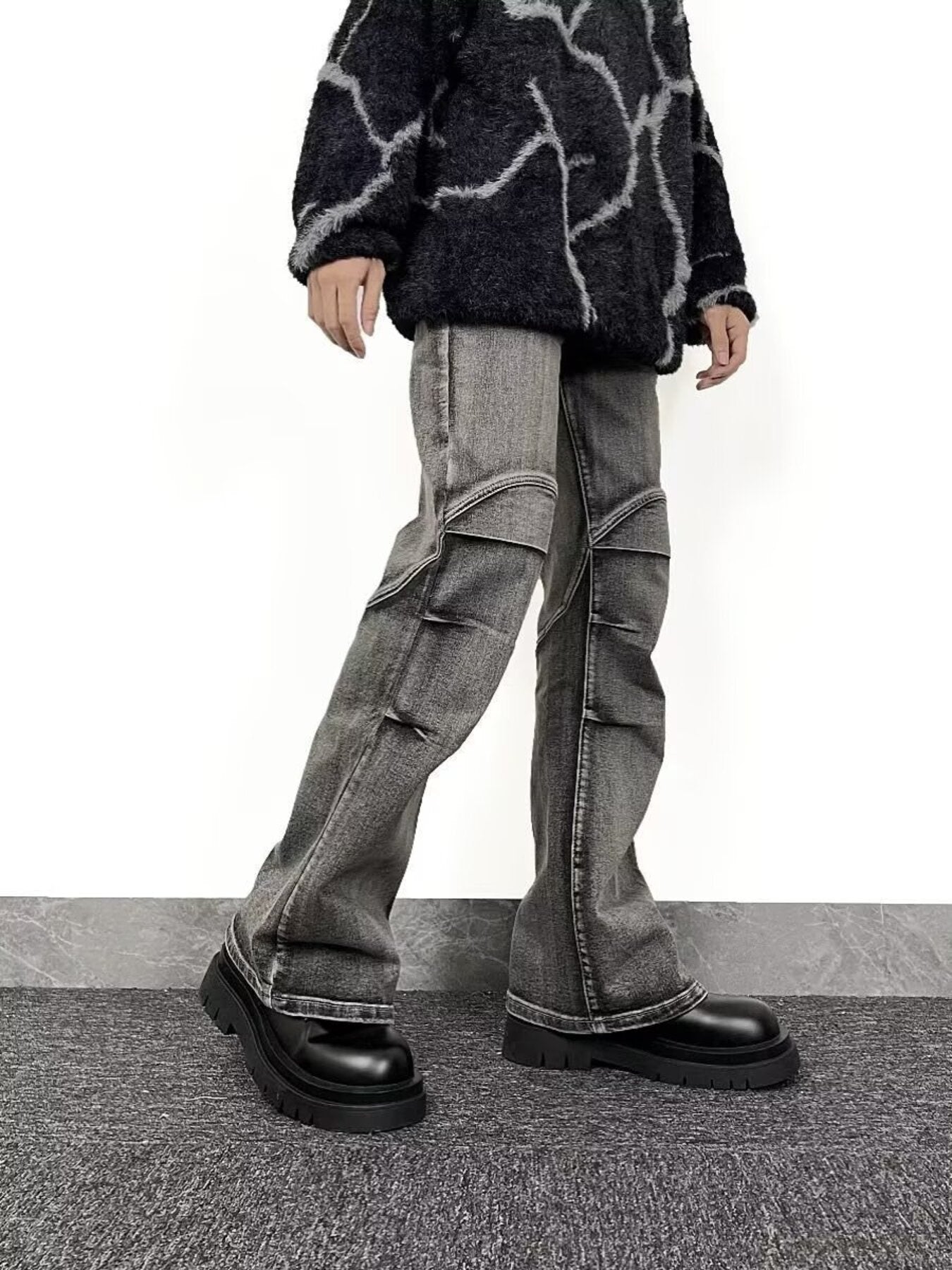 Men's relaxed fit washed flare jeans in grey denim with distressed details and paneling.