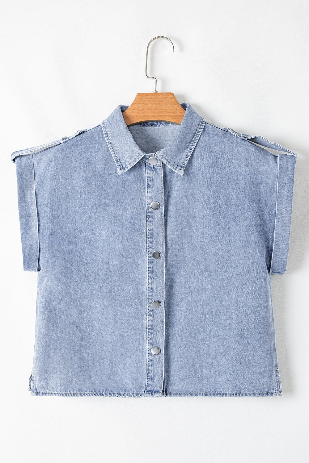 Light blue denim shirt jacket with rolled sleeves and button front, detailed with epaulets.