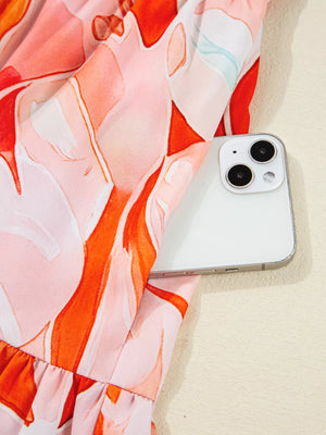 Vibrant abstract print mini dress with tiered hem and ruffled detail, showing a phone pocket.