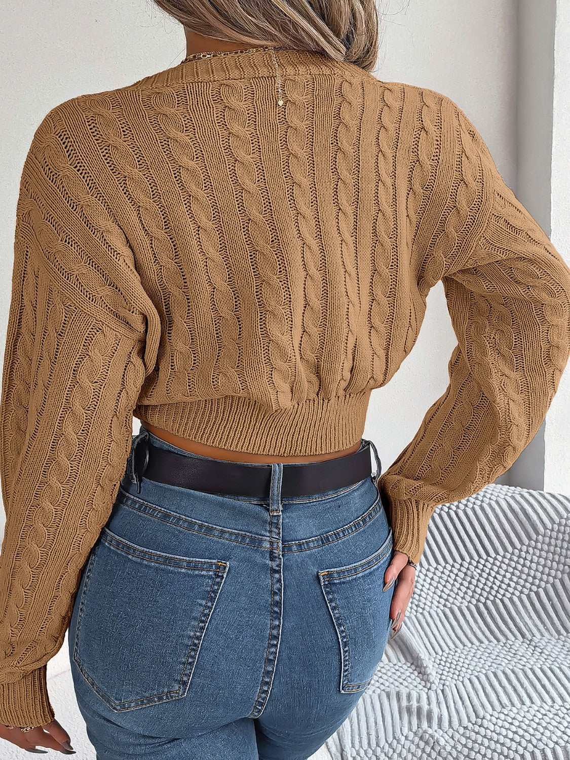 Camel cable knit cropped sweater with twist front detail and balloon sleeves.