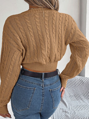 Camel cable knit cropped sweater with twist front detail and balloon sleeves.