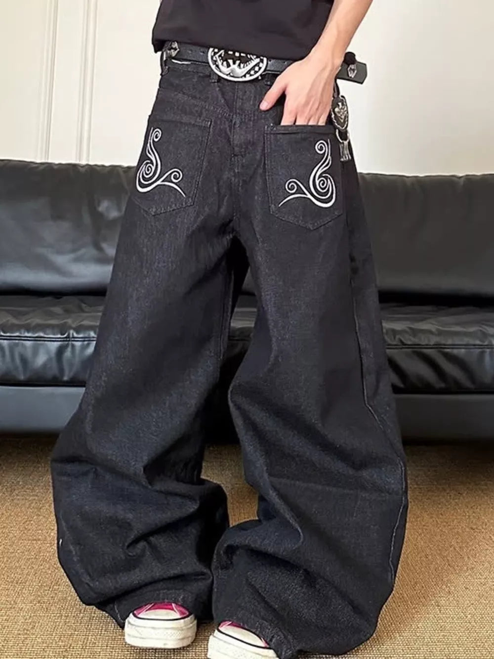 Men's dark wash wide-leg jeans with white embroidered back pockets.