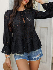 Black eyelet embroidered peplum blouse with tie neck and ruffled cuffs.