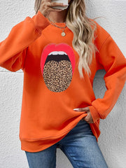 Orange sweatshirt with a bold red lips and leopard tongue graphic.
