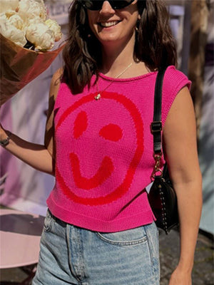 Pink knit tank top with red smiley face graphic and crew neck.