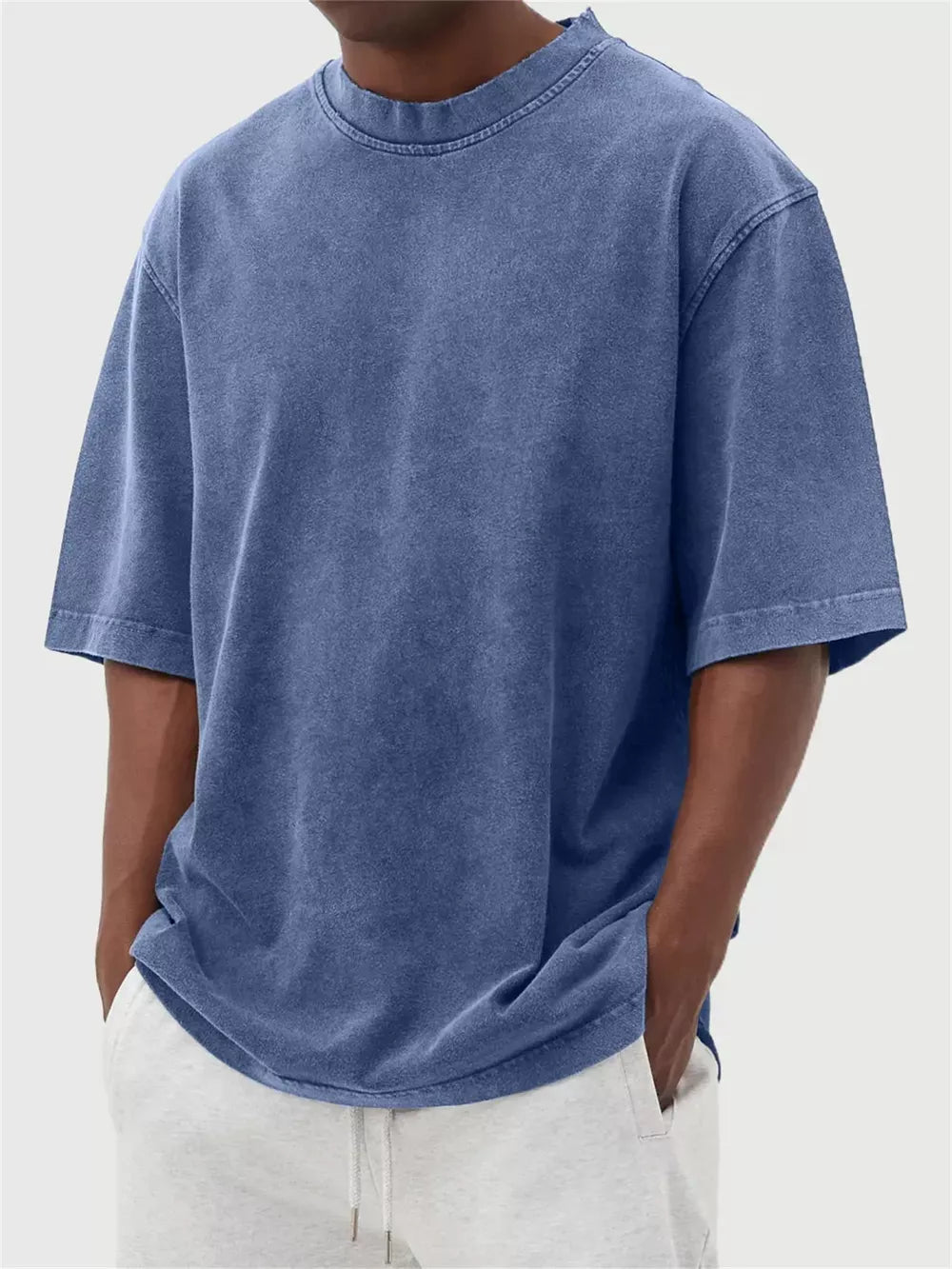 Men's blue vintage wash oversized cotton crew neck t-shirt with distressed neckline.