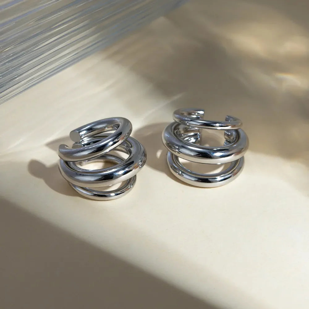 Sculptural silver ear cuff and hoop earrings with layered design